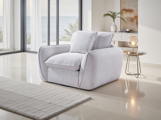 Gray armchair in a modern living room with large windows and minimal decor.