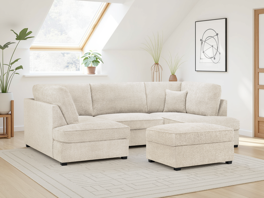 Beige sectional sofa in a living room with plants and a rug.