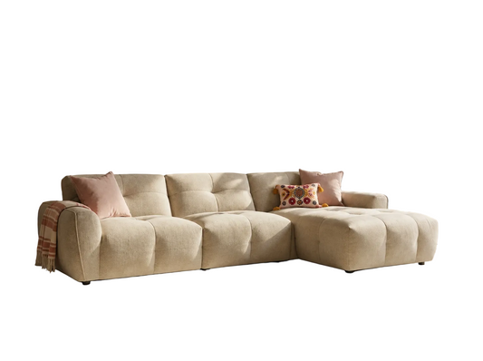 A modern beige sectional sofa with a chaise lounge on the right side, isolated on a white background.