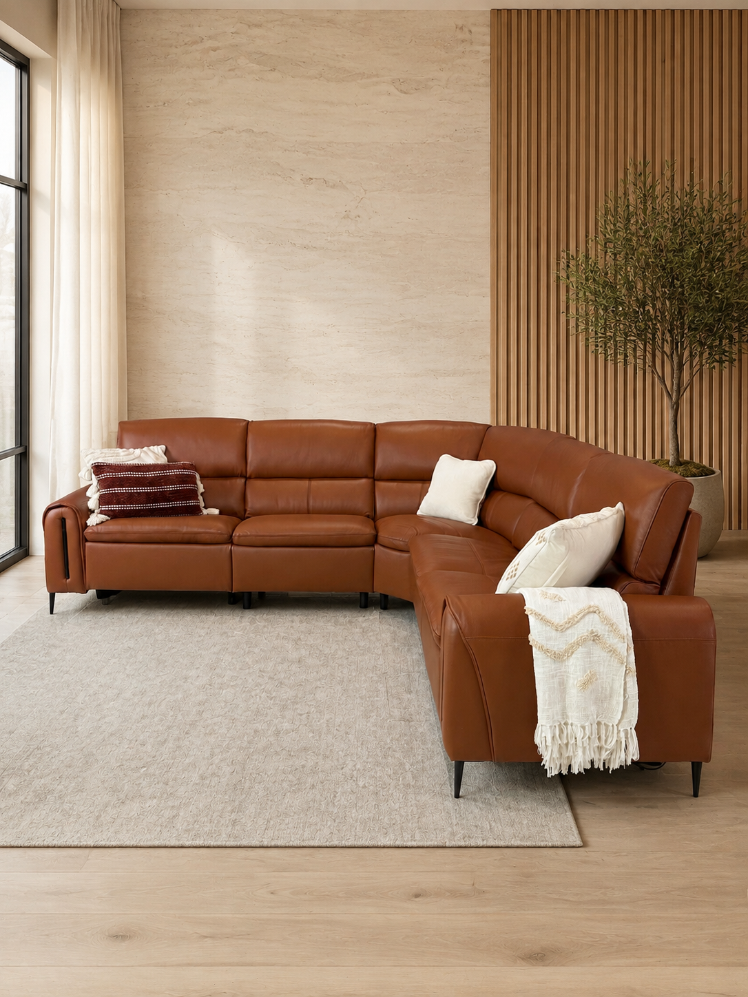 A curved brown leather sectional sofa styled in a modern living room.
