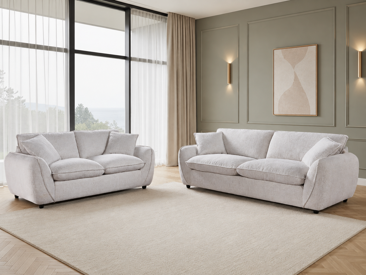 A modern living room featuring two plush light beige upholstered sofas, one loveseat and one sofa.