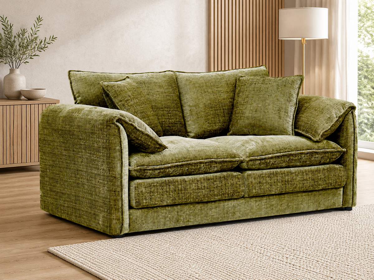 An olive green textured velvet loveseat sofa with matching throw pillows, styled in a modern living room setting with a wooden sideboard, floor lamp, and neutral rug.