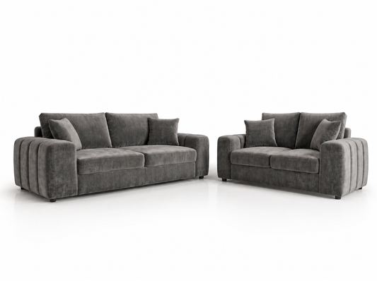 A dark gray velvet three-seater sofa and a matching two-seater loveseat with matching throw pillows, shown on a clean white background.
