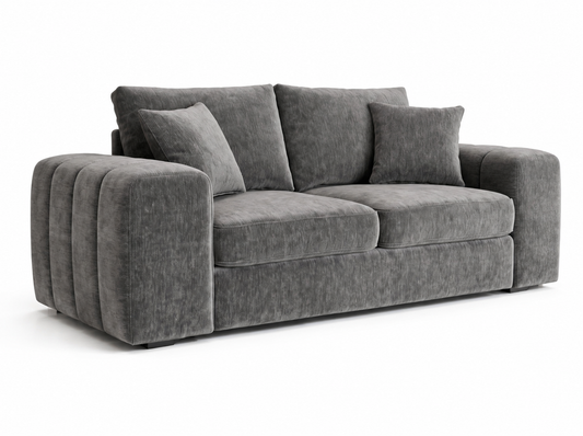 A modern three-seater sofa upholstered in textured gray fabric, featuring a chunky pleated armrest on the left and two matching throw pillows, shown against a plain white background.