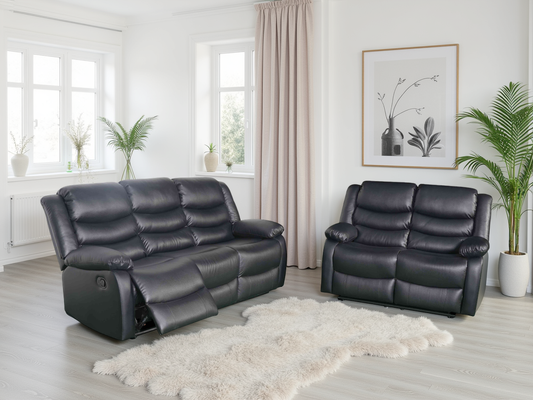 Black leather recliner sofa set in a living room with plants and decor.