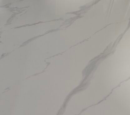 A close-up of a light gray to off-white marble or quartzite surface with soft gray veining running diagonally across the frame.