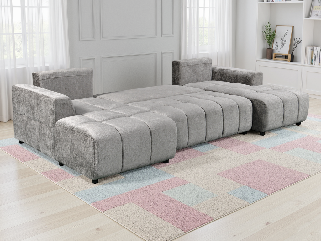 Gray sectional sofa in a room with a checkered rug and white walls.