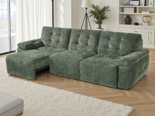 Green sectional sofa in a living room with a rug and plants.