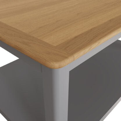 Close-up of a table corner showing a light oak wood top with rounded edges and a gray metal frame and leg.