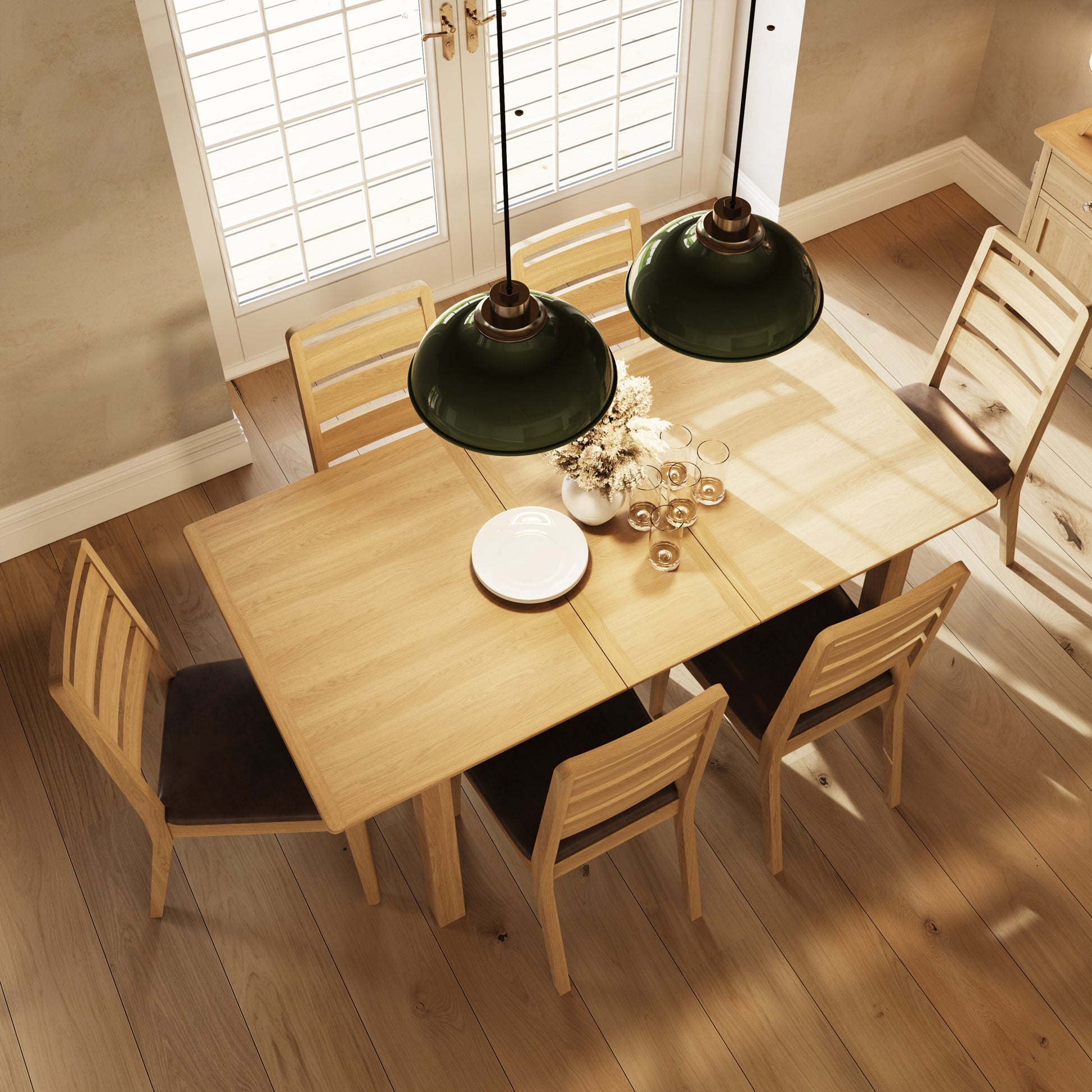 Dining room with wooden table and chairs under green pendant lights.