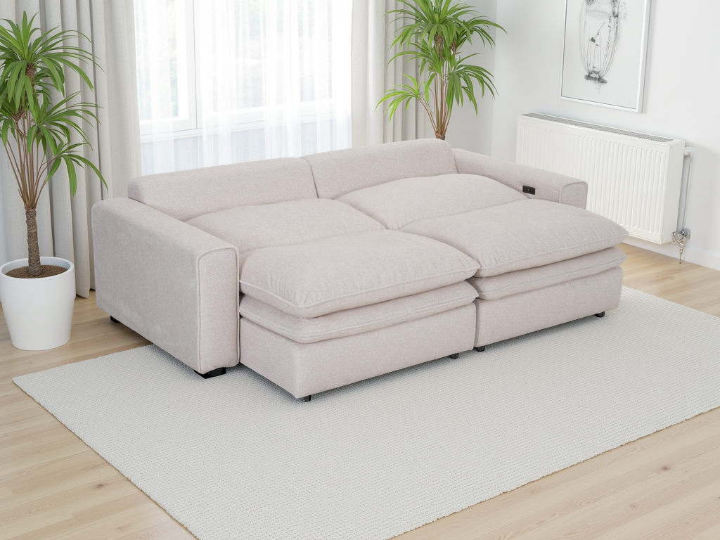 Beige sectional sofa in a room with light wood flooring and white curtains.