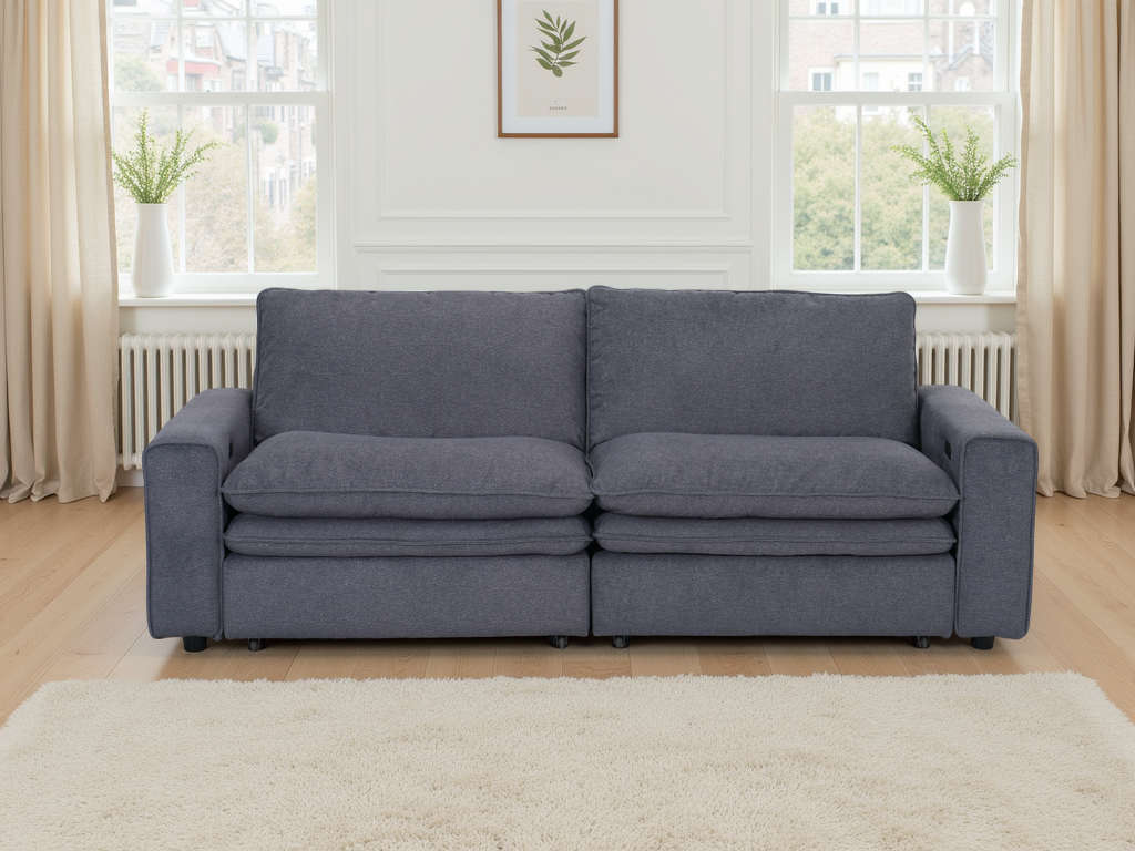 Gray sofa in a living room with large windows and light decor