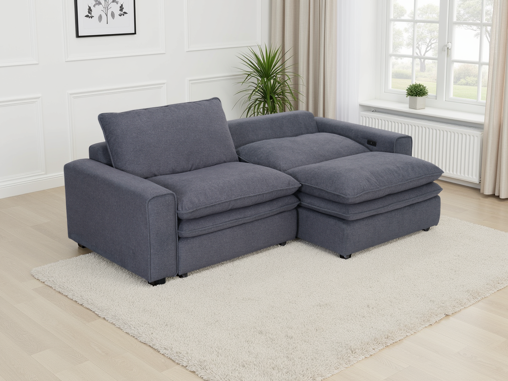 Gray sectional sofa in a living room setting with a plant and window in the background.
