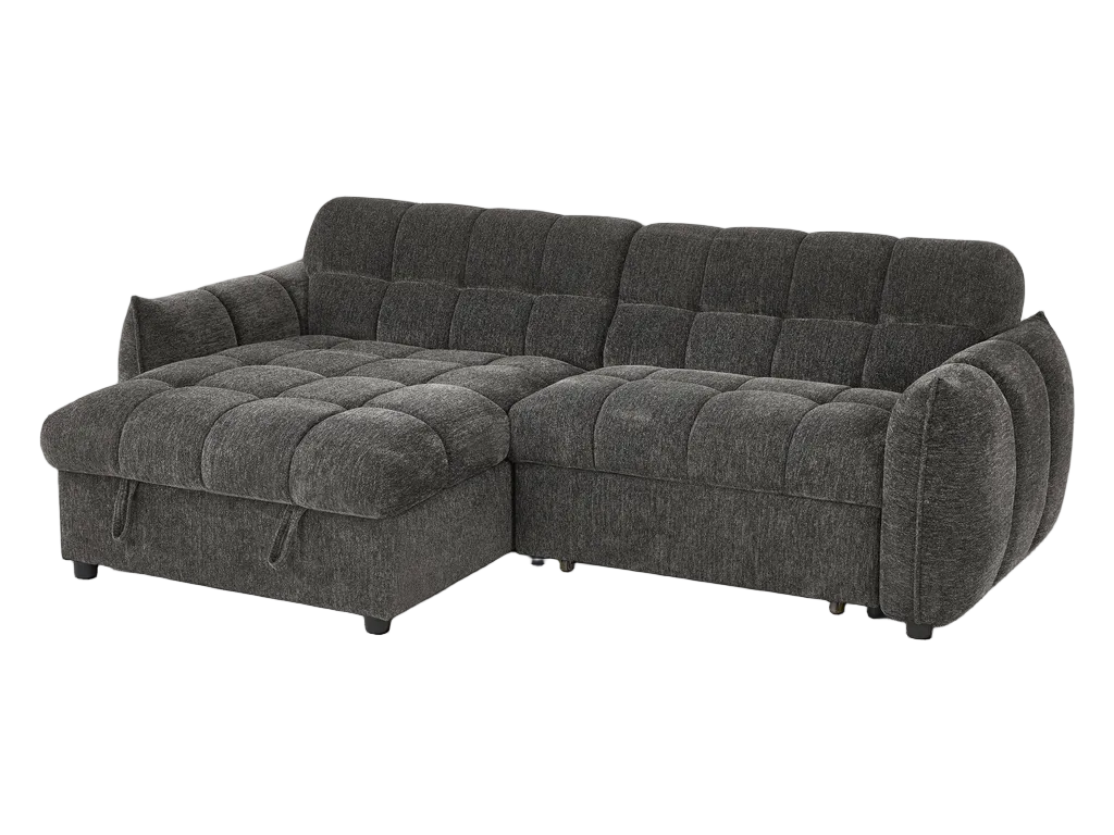 Gray sectional sofa in a living room setting with a lamp and fireplace in the background.