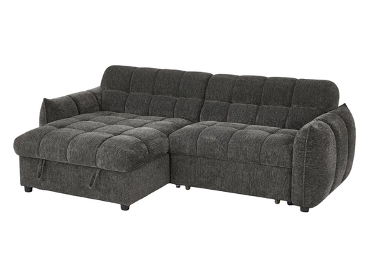 Gray sectional sofa in a living room setting with a lamp and fireplace in the background.