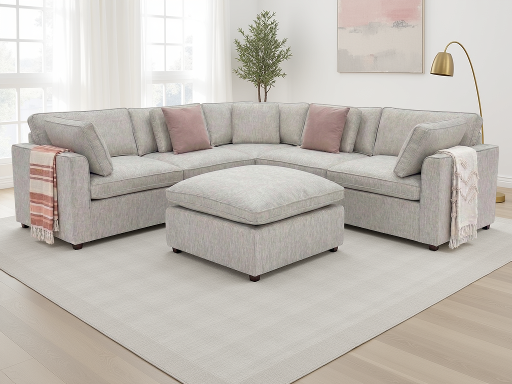 Gray sectional sofa with pink cushions in a living room setting.
