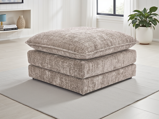 Textured ottoman in a room with a plant and shelves.