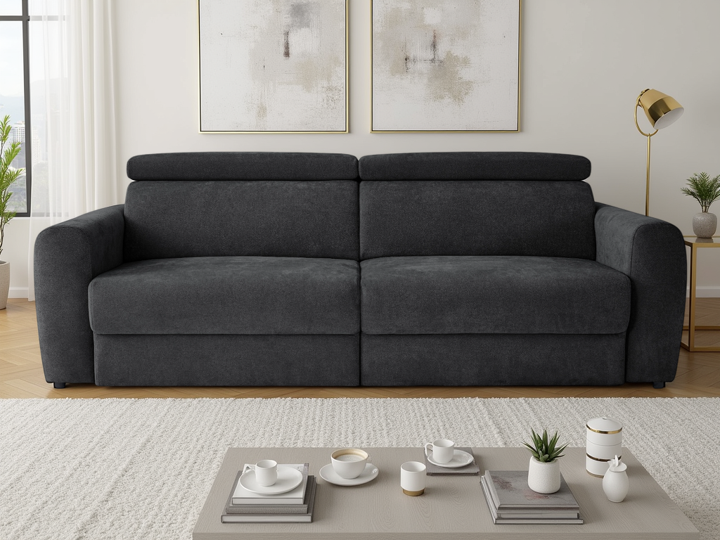 Black sofa in a living room with a coffee table and decor items.k
