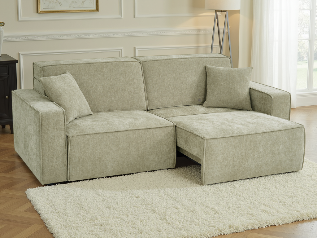 A light beige upholstered sectional sofa with a chaise lounge on the right side, shown in a bright living room setting on a white shag rug.