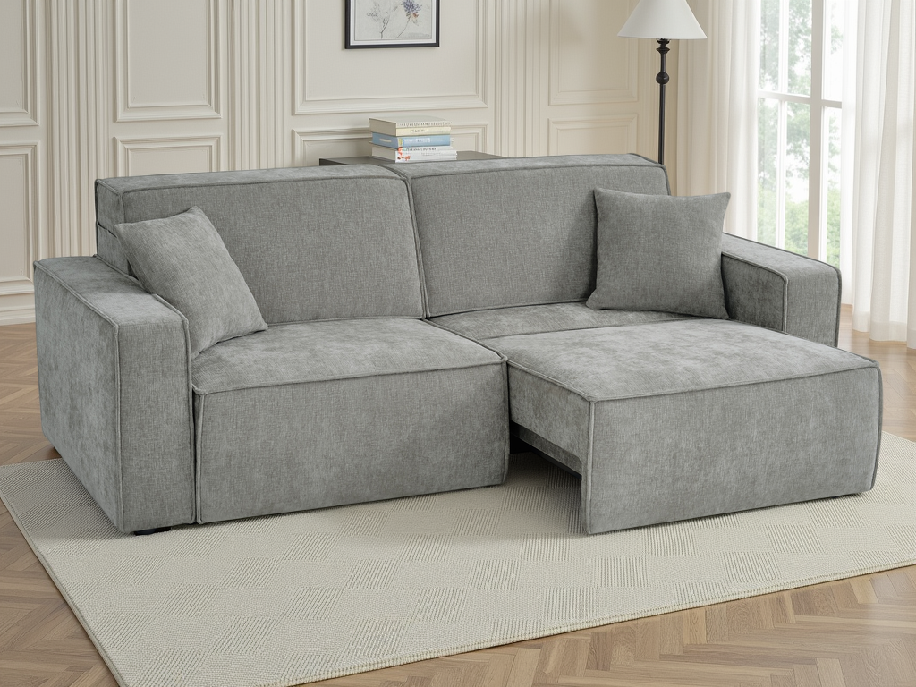 A light gray fabric sectional sofa with a chaise lounge on the right side, shown in a bright, modern living room setting.
