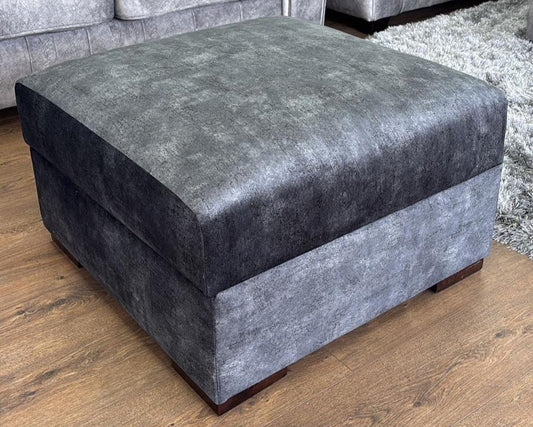 Black upholstered ottoman on a wooden floor