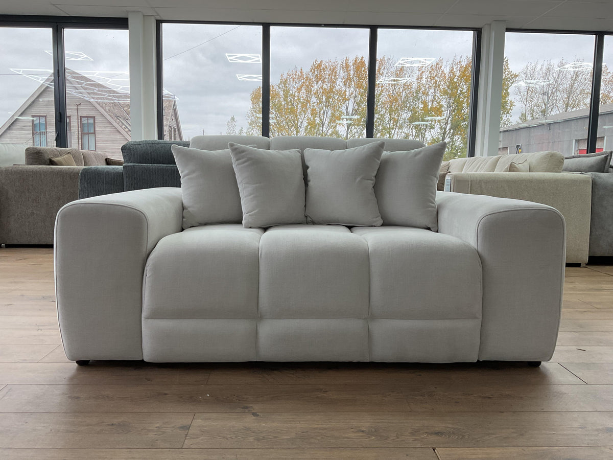 beige sofa with cushions in a room with large windows
