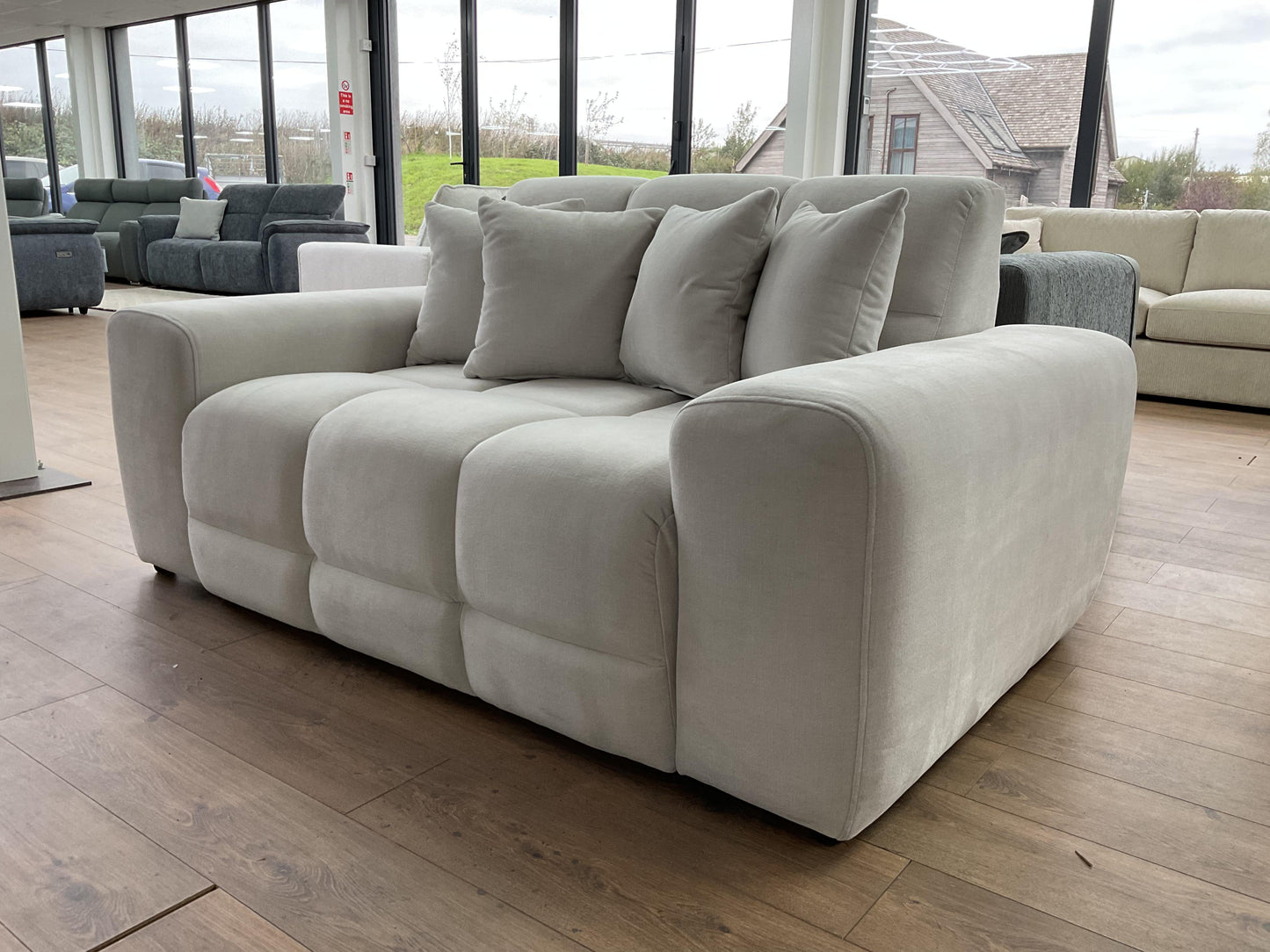 Beige sofa with cushions in a showroom setting