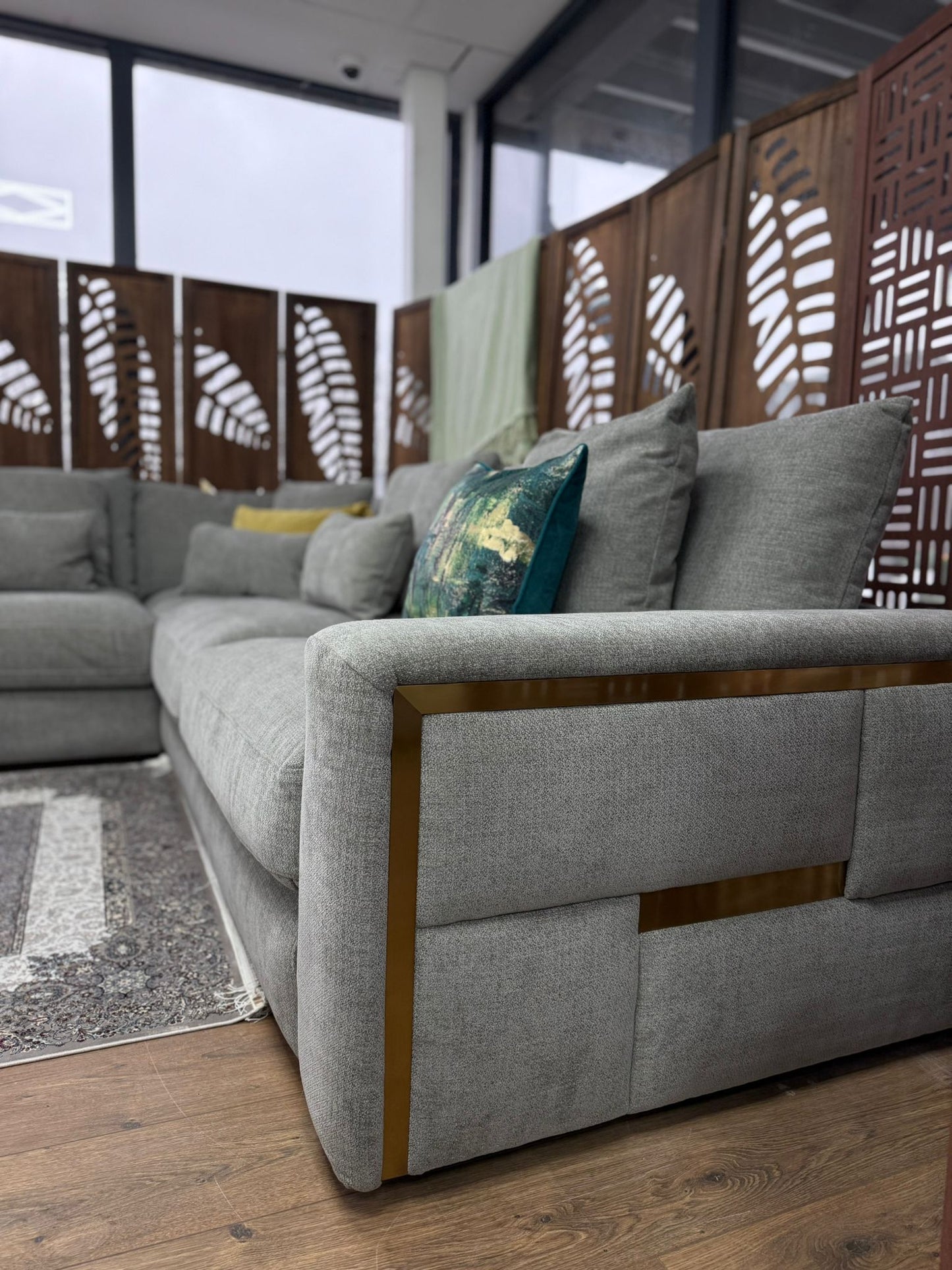 Gray sectional sofa with decorative pillows in a modern indoor setting.