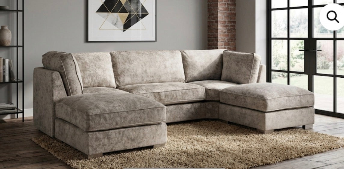A light beige textured fabric sectional sofa with a left-facing chaise lounge and a right-facing chaise lounge, set in a modern living room.