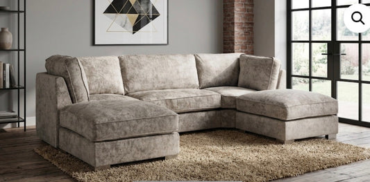 A light beige textured fabric sectional sofa with a left-facing chaise lounge and a right-facing chaise lounge, set in a modern living room.
