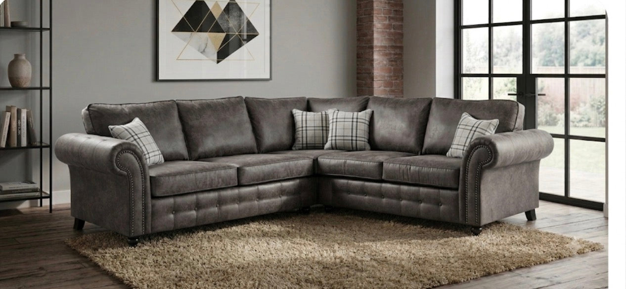 A grey upholstered corner sofa shown in a modern living room setting.
