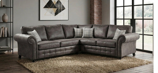 A grey upholstered corner sofa shown in a modern living room setting.
