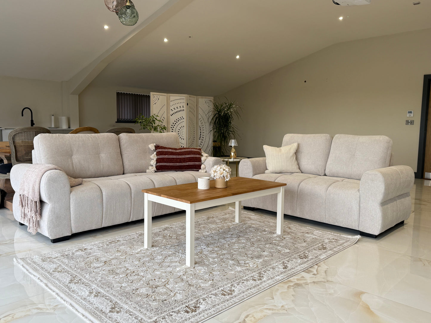 Modern living room with beige sectional sofa, wooden coffee table, and decorative items.