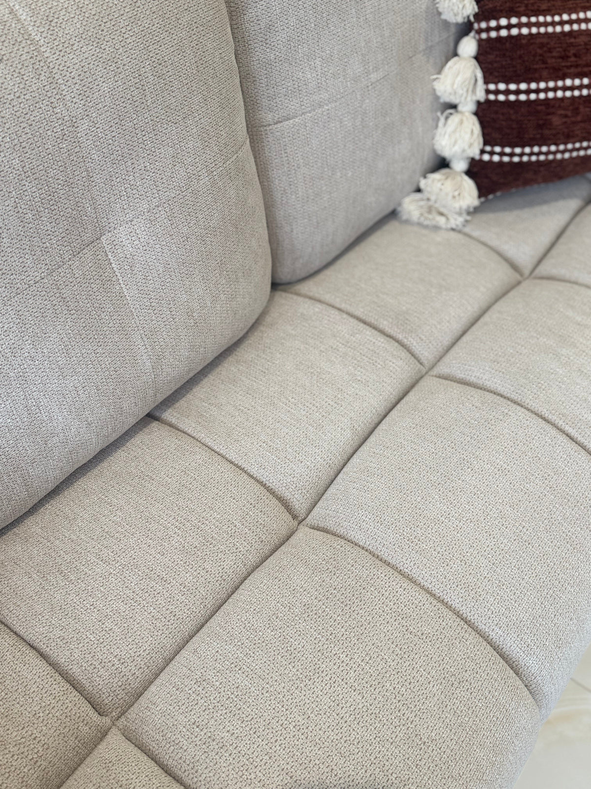 Close-up of a beige fabric sofa with a textured pattern