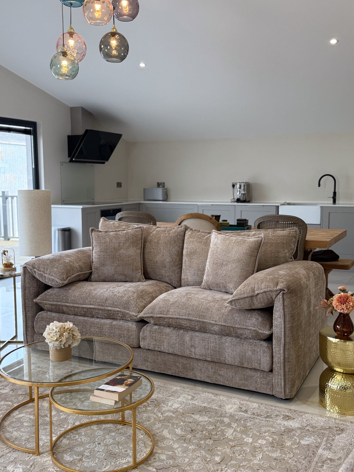 Modern living room with a beige sofa, coffee table, and decorative elements.