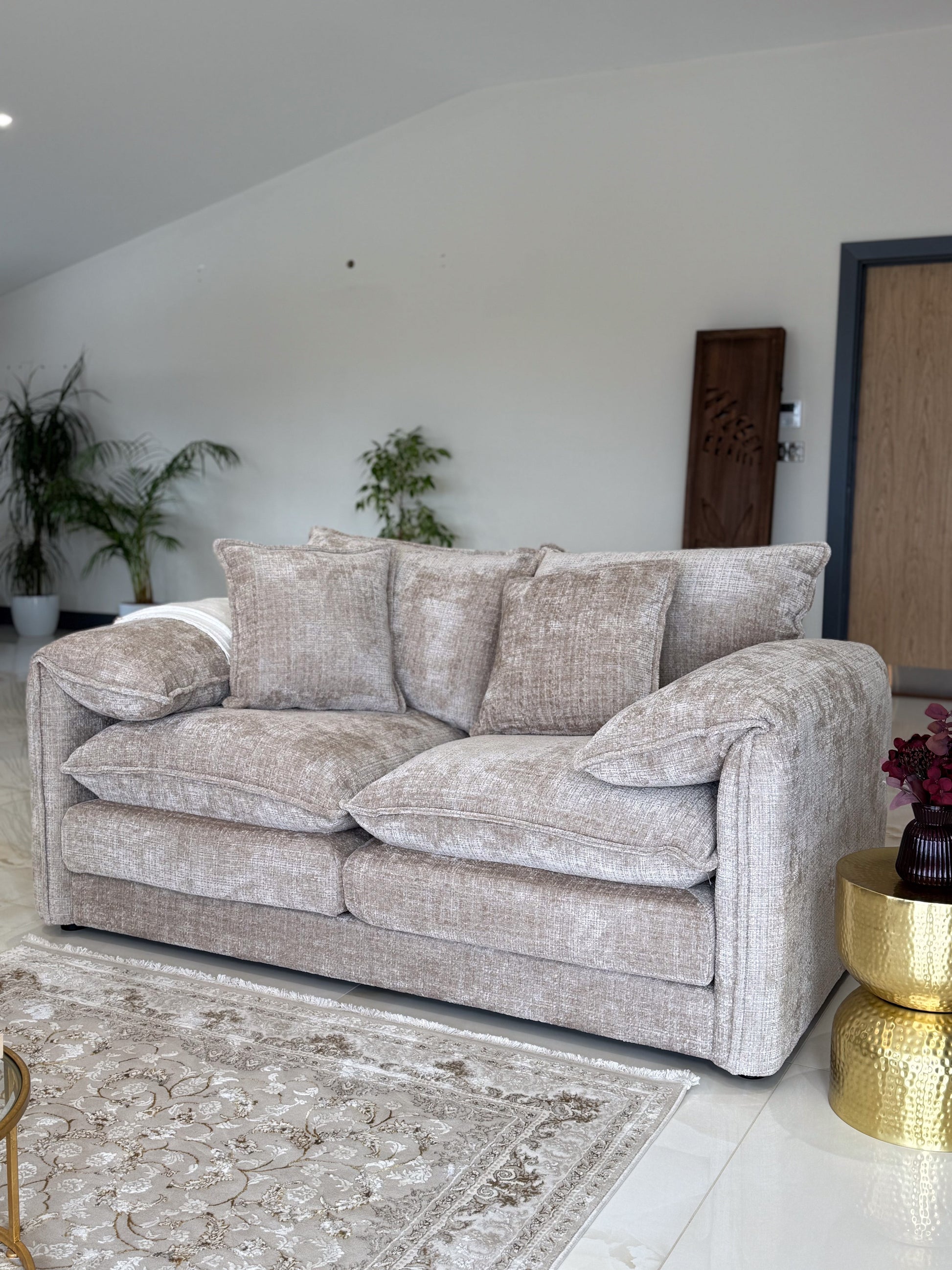 Beige in a living room with a gold side table and plants.