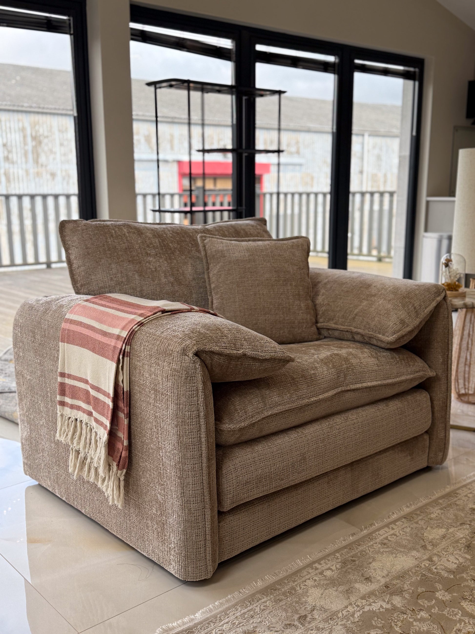 Beige sofa with a blanket in a living room setting