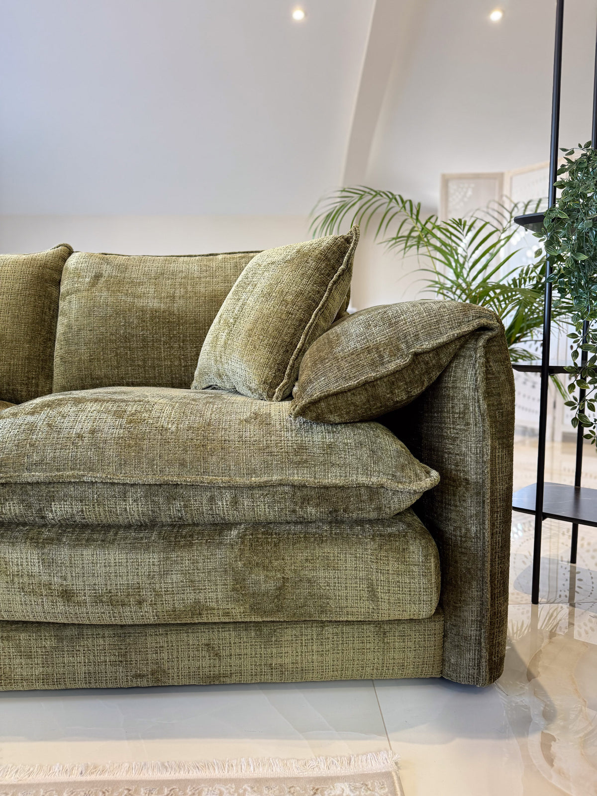 Green sofa with cushions in a modern living room setting