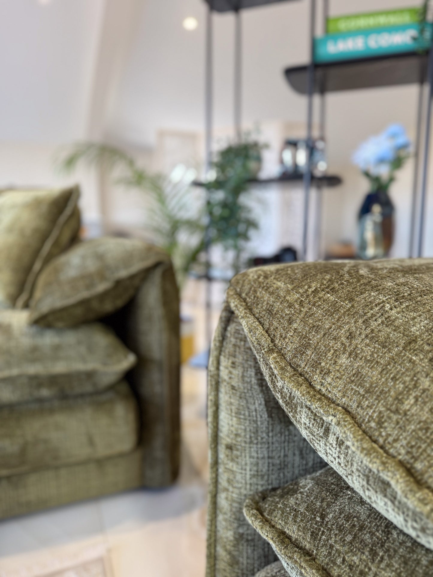 Green textured armchair in a room with a blurred background