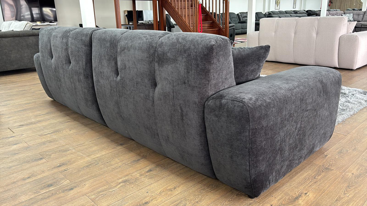 Black sofa in a living room setting with other furniture.
