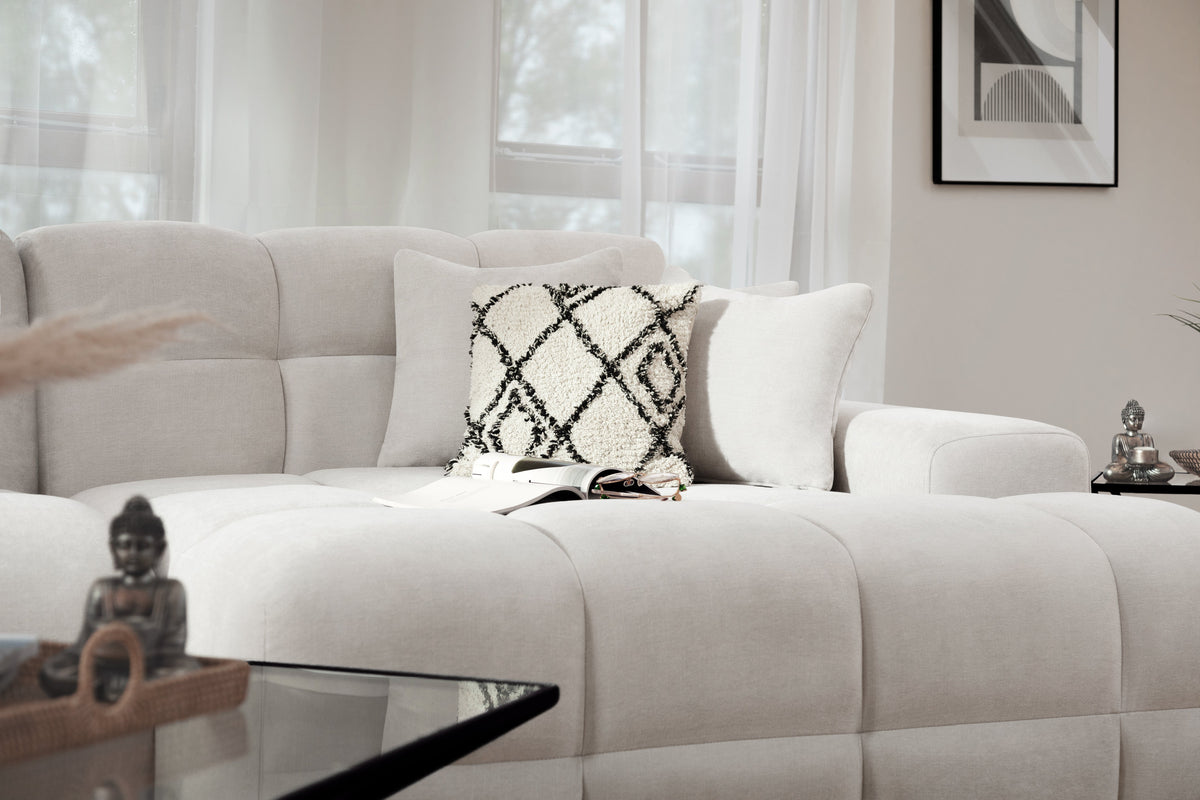 Beige sofa with decorative pillow in a living room setting