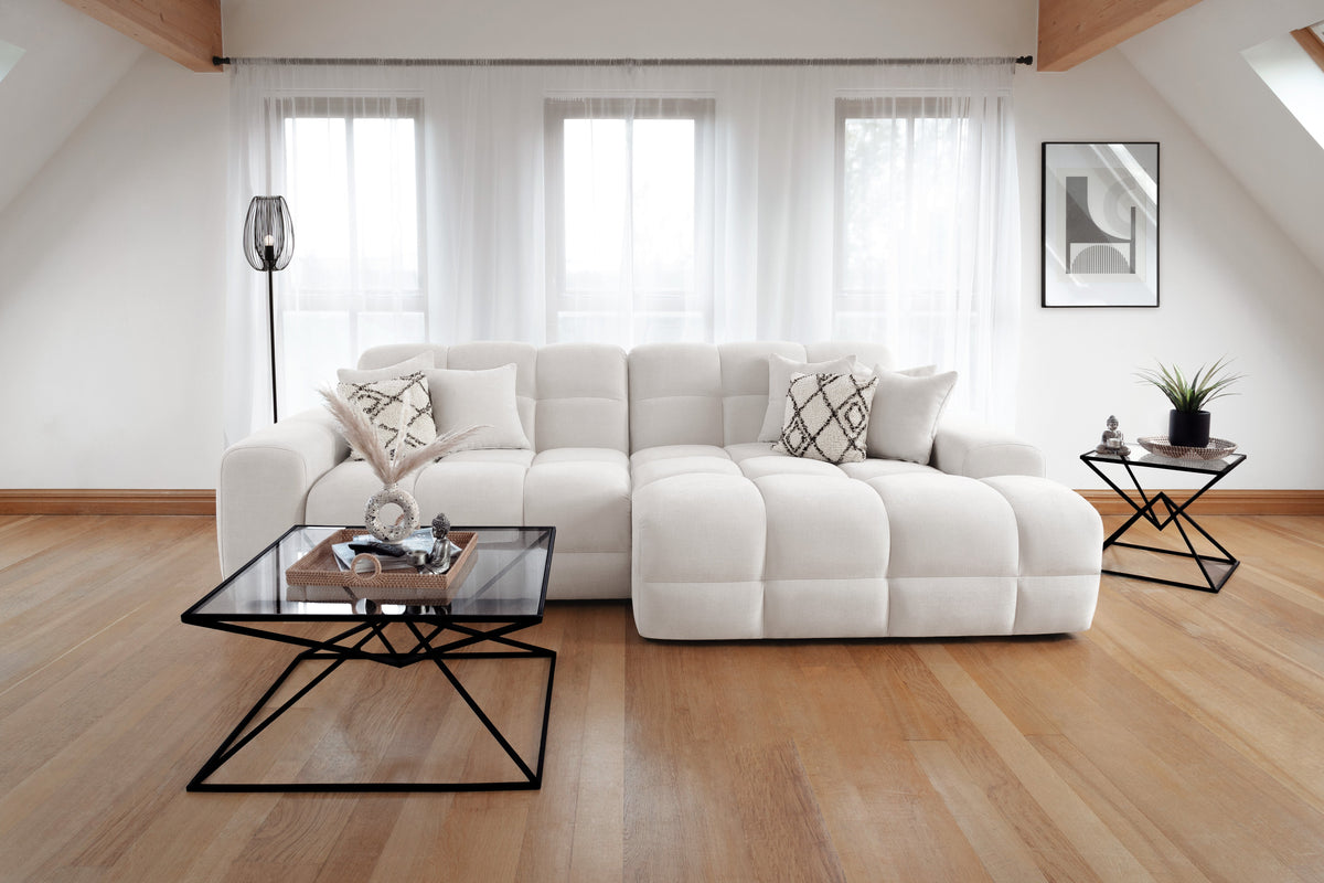 Modern living room with a white sectional sofa, coffee table, and decorative items.