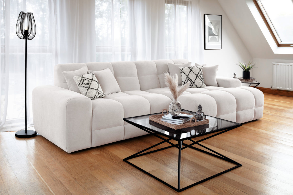 Modern living room with a white sectional sofa, coffee table, and decorative items.