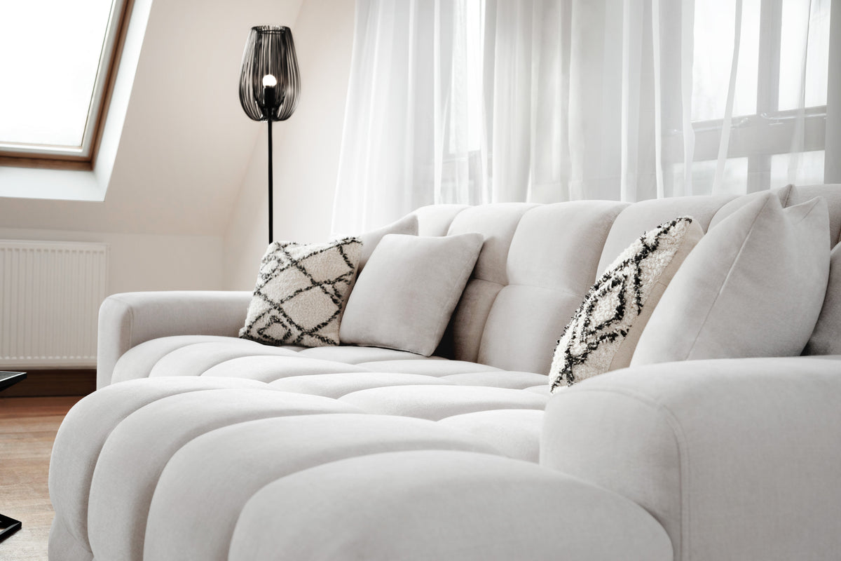 White sofa with patterned cushions in a bright living room