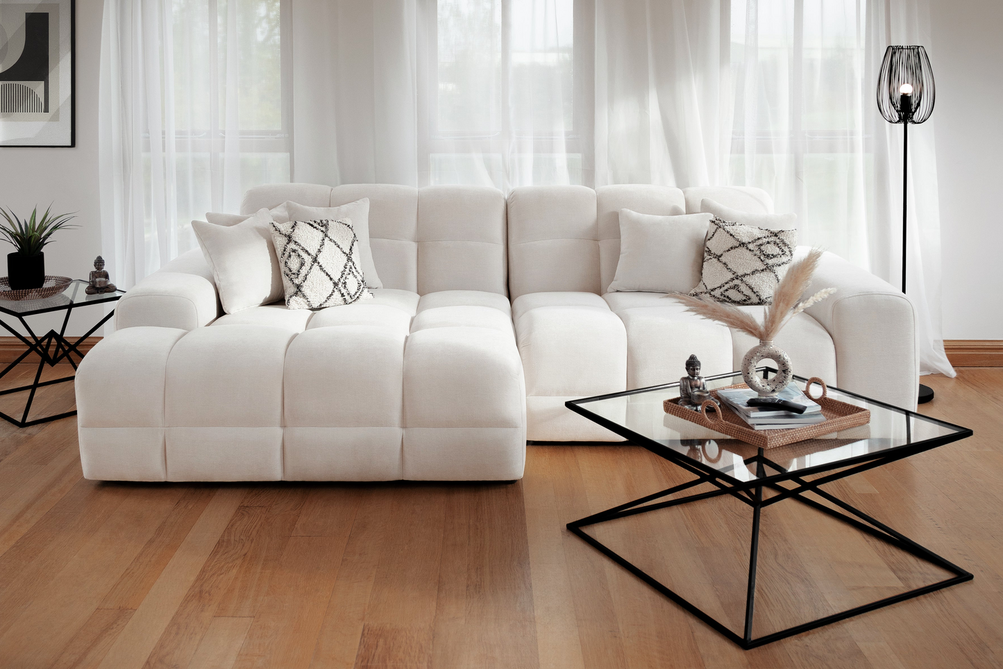 Modern living room with a white sectional sofa and glass coffee table.