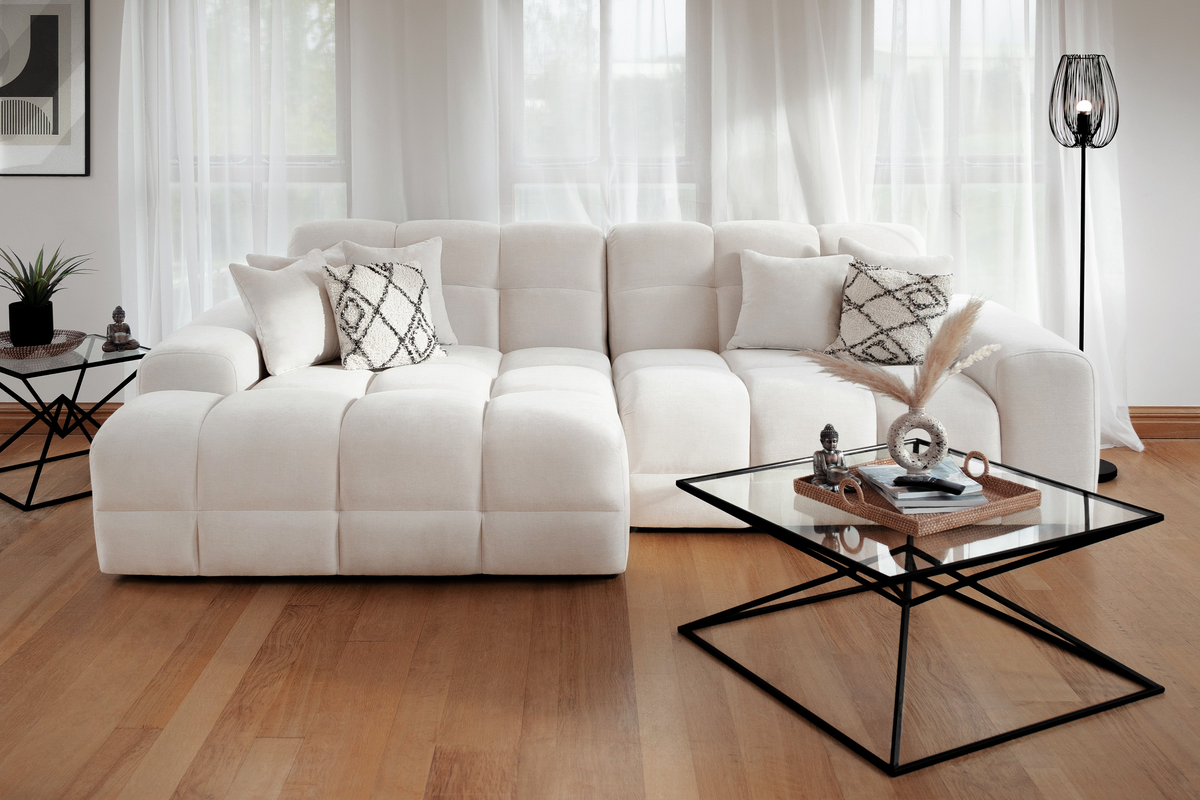 Modern living room with a white sectional sofa and glass coffee table.