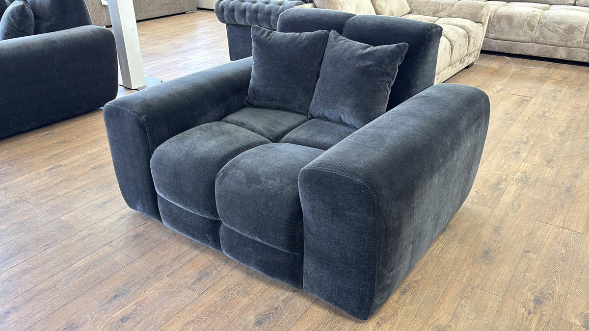 Black sofa with cushions on a wooden floor in a living room setting