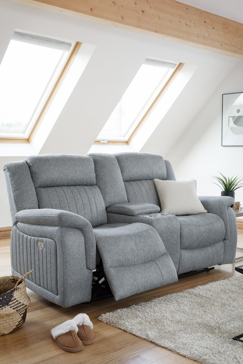 Gray recliner sofa in a room with wooden floor and skylights