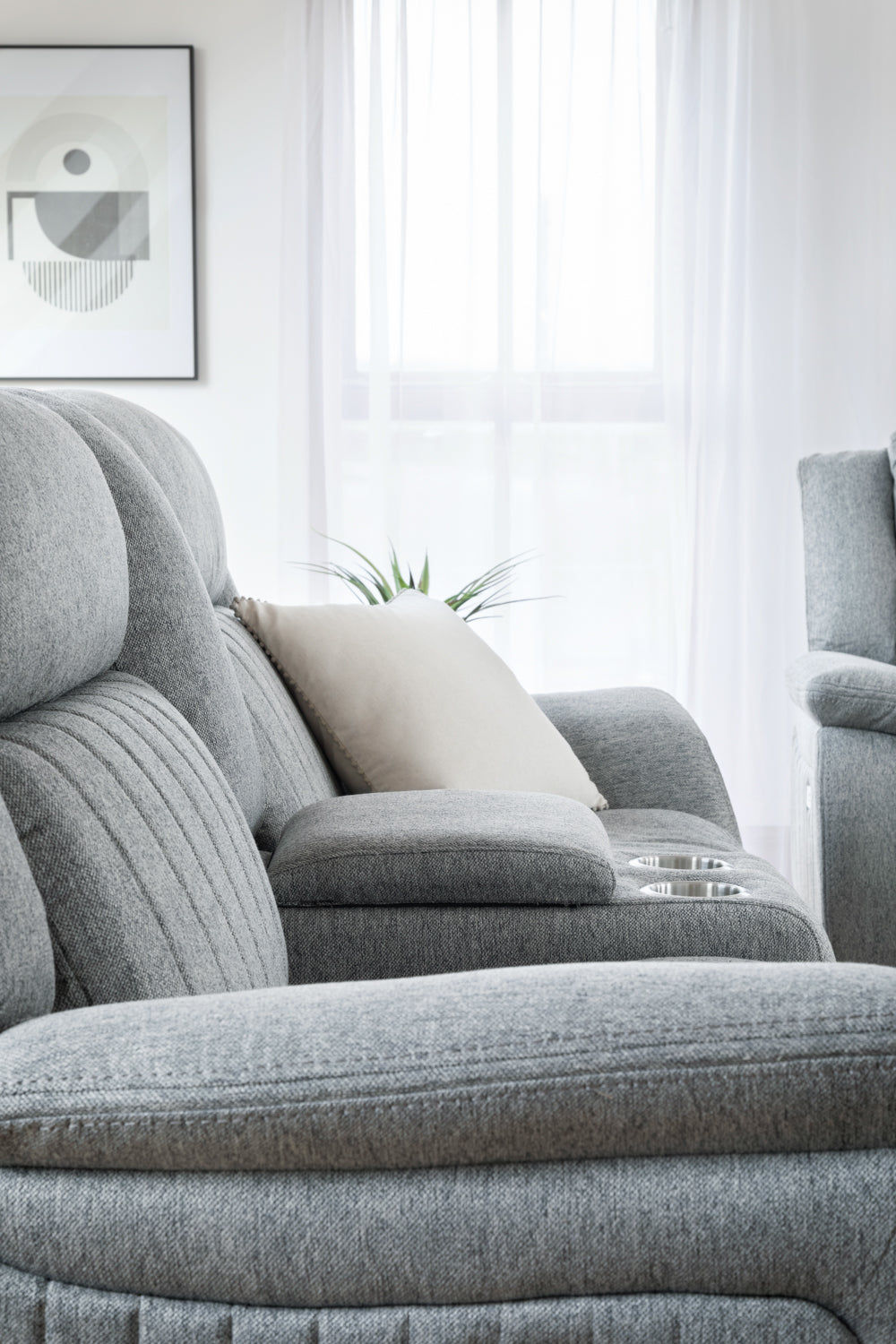 Gray recliner sofa in a living room with a neutral color scheme.