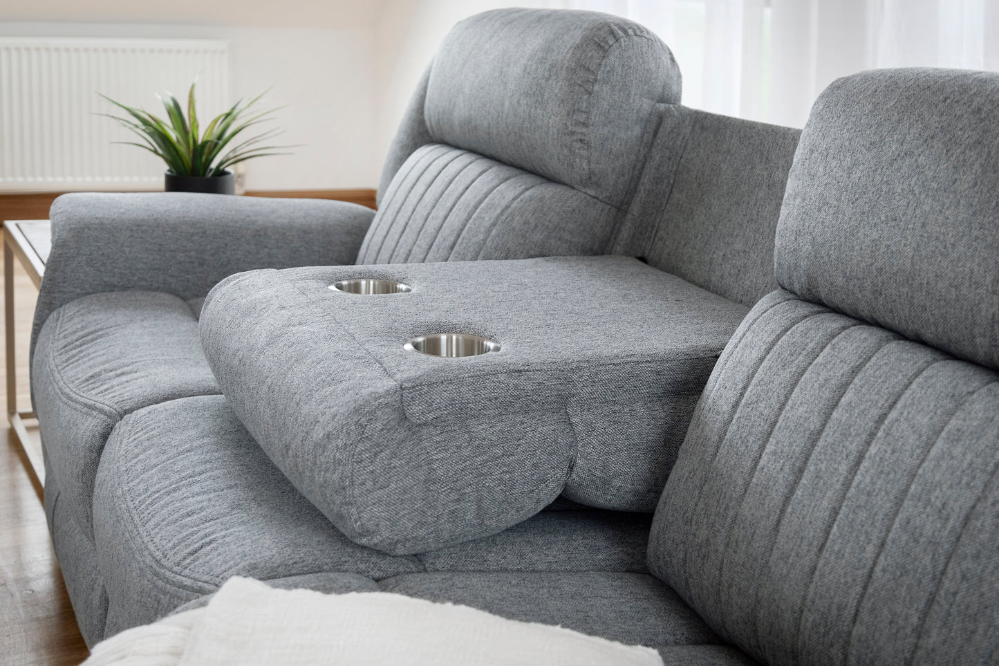 Gray sofa with cup holders in a living room setting